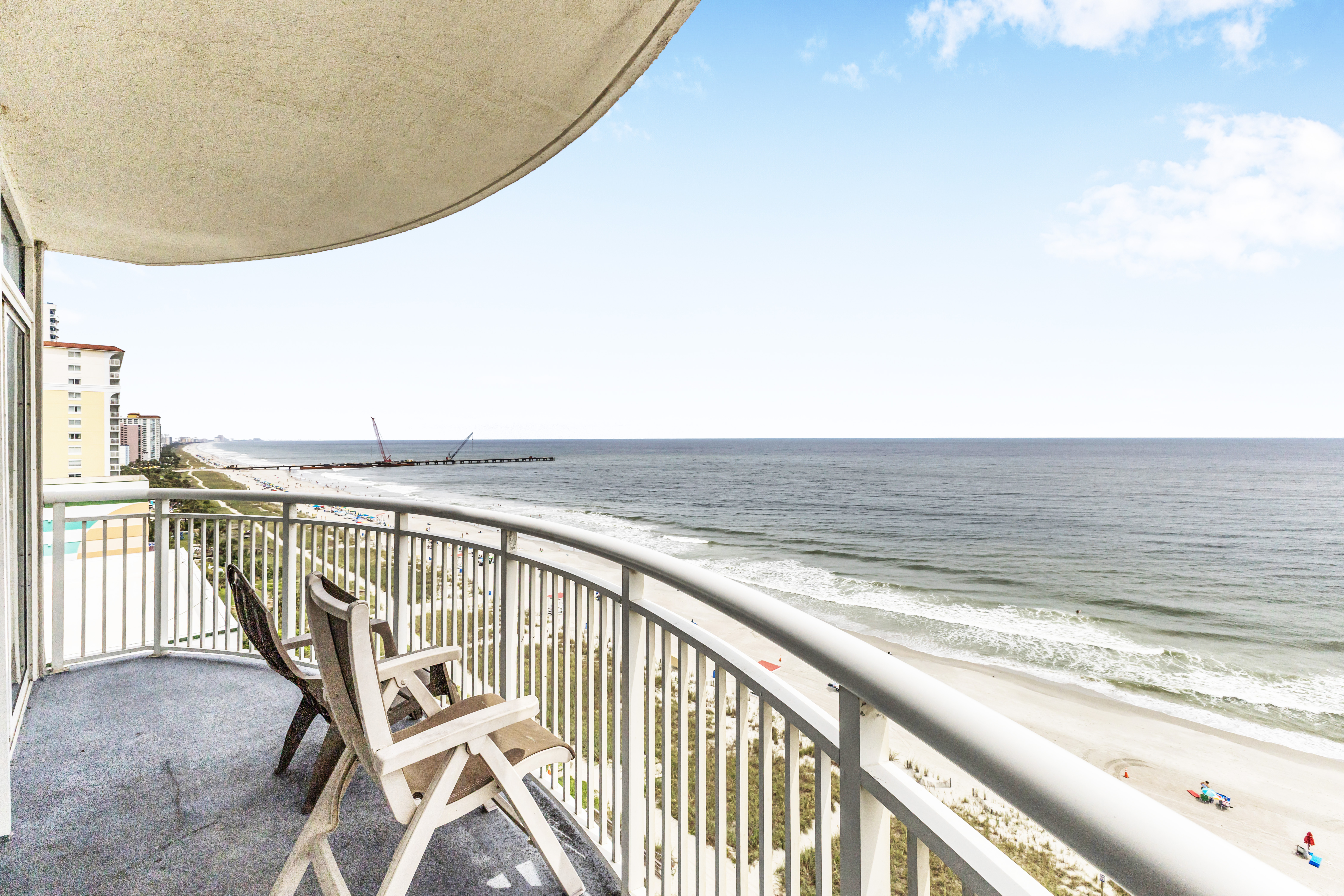 A balcony with a view of the ocean and beach